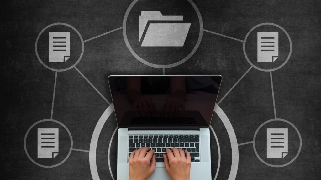 hands typing on laptop with folder logos surrounding it