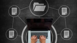 hands typing on laptop with folder logos surrounding it