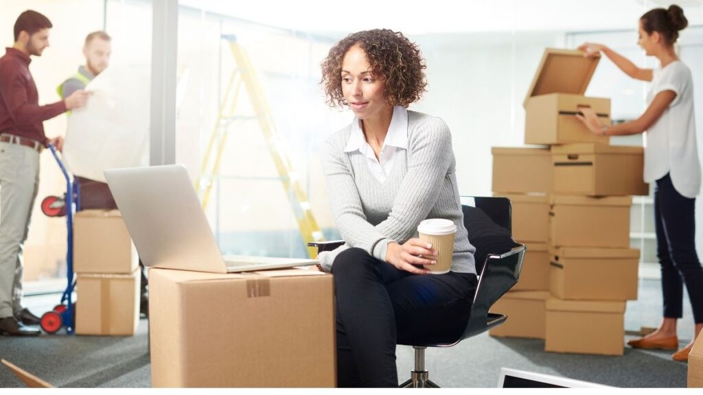 three people unpacking boxes in a new office