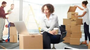 three people unpacking boxes in a new office