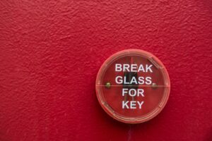 break glass for key sign on a red wall