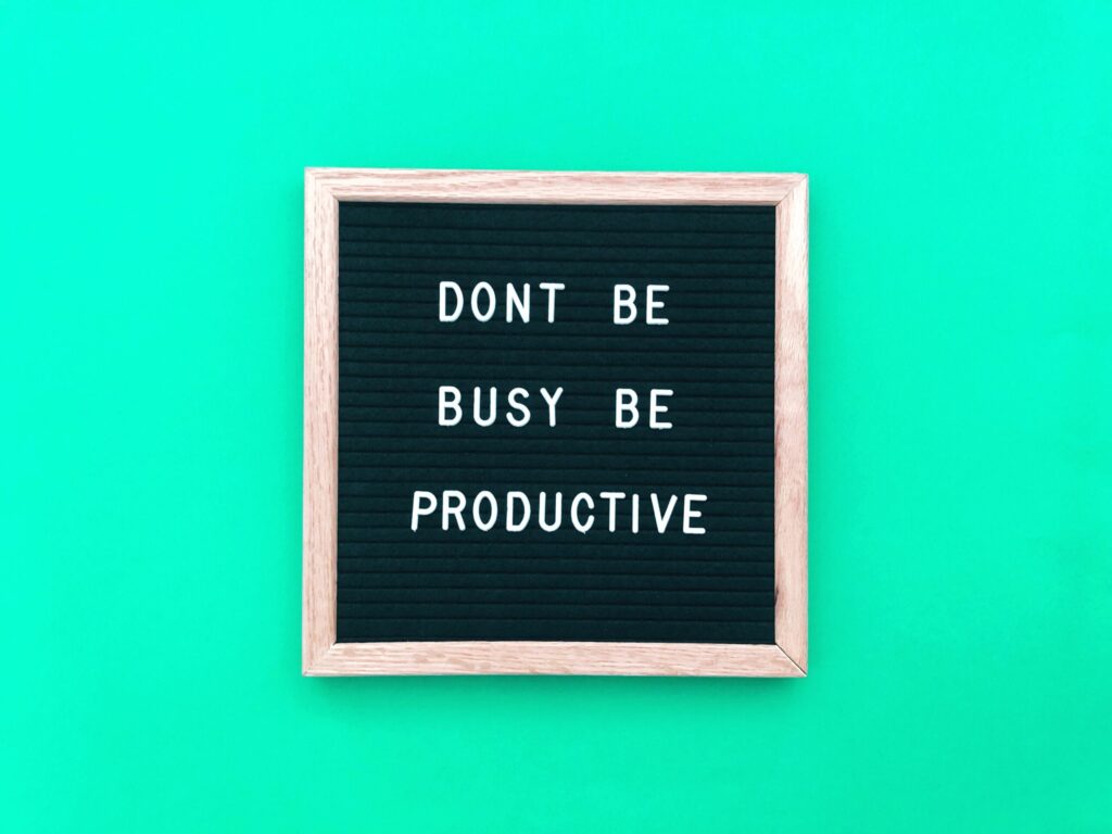 letters on a blackboard spelling out don't be busy be productive