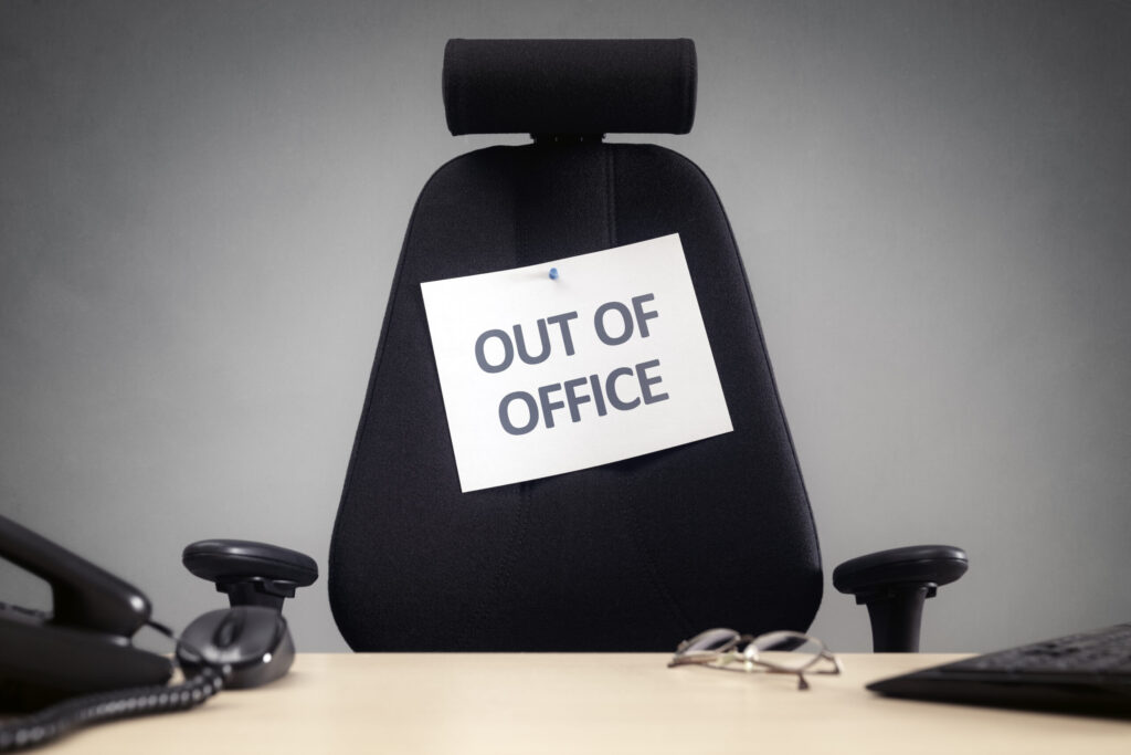 black office chair with OUT OF OFFICE sign on it