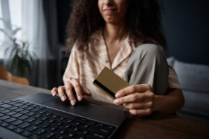 girl making a secure online payment with a bank card and laptop at home