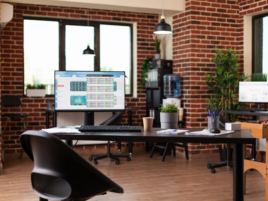 brownstone office with monitor on desk showing statistics